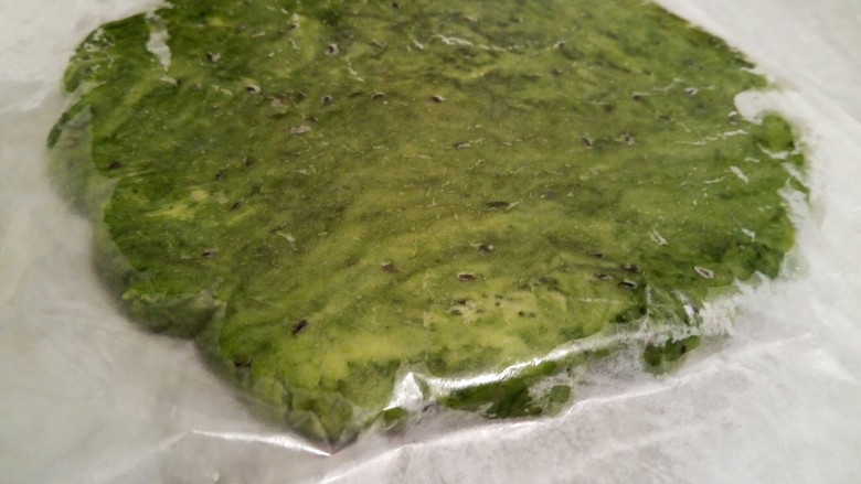 抹茶油酥饼干,将面团揉圆压扁,放在两张油纸中间,用擀面杖擀开,擀成大约0.5的面片(擀得要比一般的饼干厚,放在两张油纸中间擀开,面团就不会粘擀面杖和案板了)