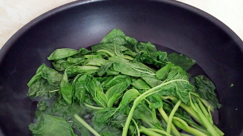 有情菜肉煎包,锅中注水,水烧开后放入有情菜烫软辍水,捞出控水。