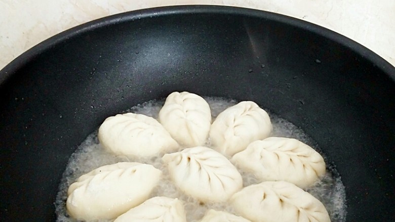 有情菜肉煎包,倒入适量,清水,水量没过包子底部。