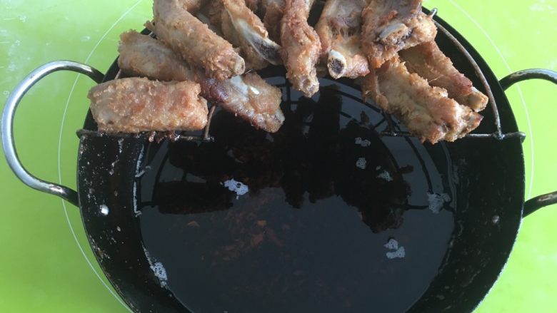 蒜香排骨,锅中加油,不用太多,把腌制好的排骨加入,炸制七分熟