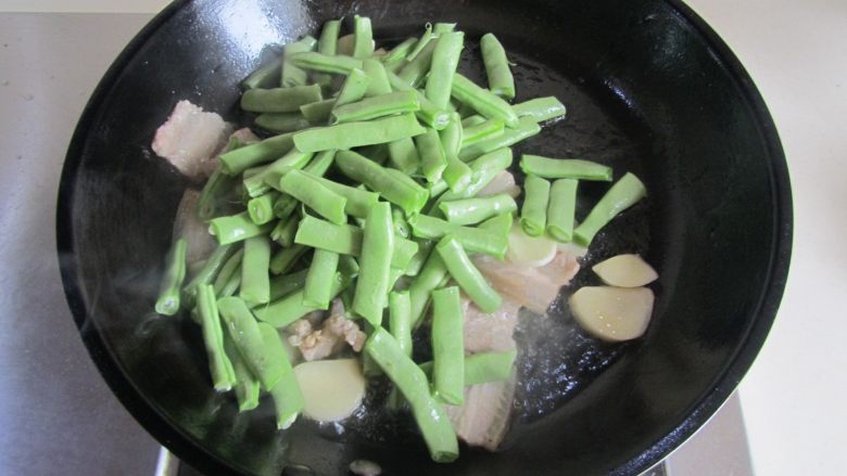 扁豆焖面,放入四季豆进去煸炒;