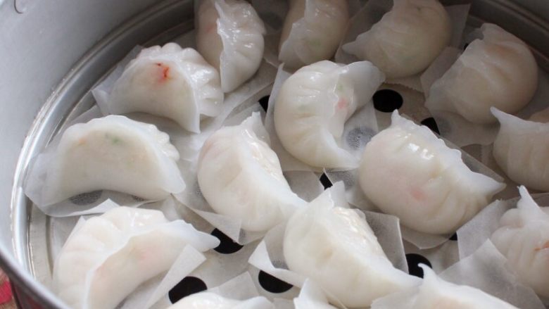 水晶虾饺,16.依次做好全部,下面垫一张油纸,摆放在蒸笼中,彼此间留有空隙。
水开上笼,大火蒸5分钟就可揭锅享用。