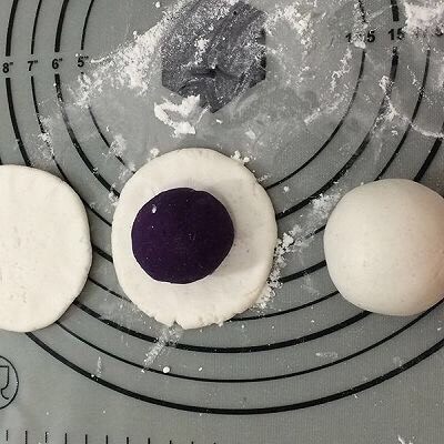 紫薯糯米饼,拿一个面团,用手捏成中间厚四周薄的饼,然后将紫薯放入饼中间,用手一点点的将紫薯包入,不要将紫薯露出