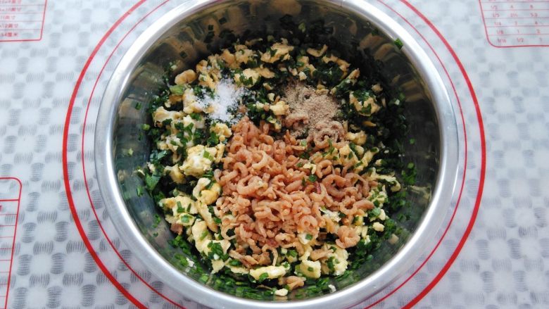 韭菜盒子(春卷版), 装有鸡蛋的盆里加入韭菜,食用油,虾米,盐,<a style='color:red;display:inline-block;' href='/shicai/ 134296'>白胡椒粉</a>搅拌均匀