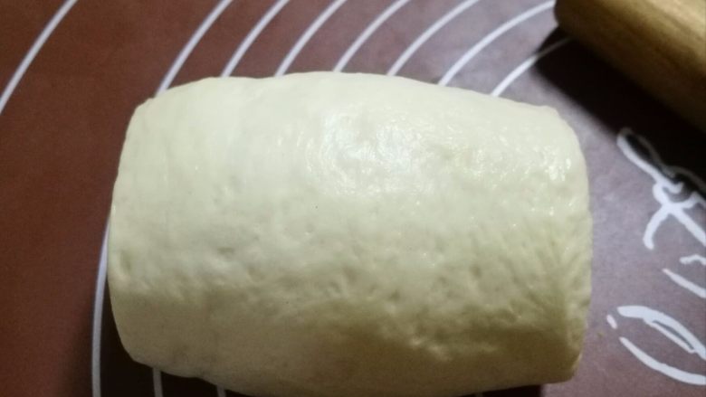 17小时中种软吐司,在擀成牛舌装，注意宽度不能超过吐司模具的宽度，边缘的气泡用手排掉，卷起来