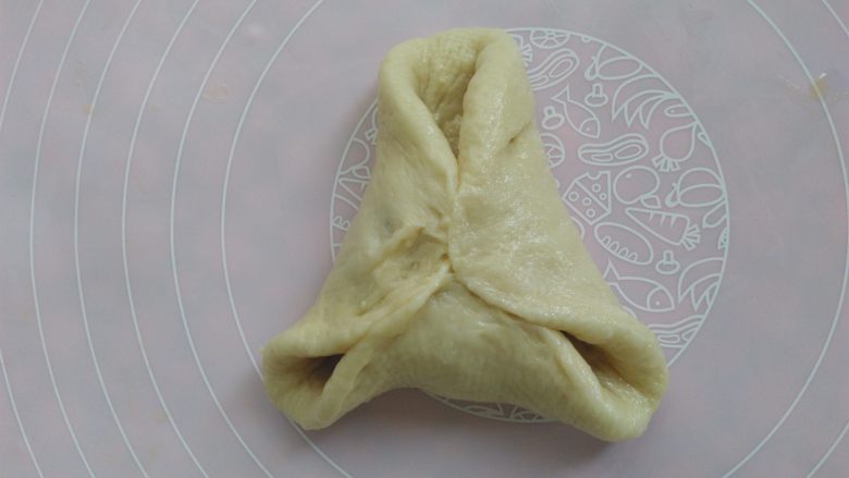 全麦蔓越莓奶酥软欧面包,把面皮的边提起来,像包糖三角一样,包起来,先把中间捏紧
