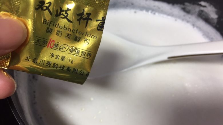 fluff棉花糖之自制百香果酸奶,关火后这时候如果牛奶温度太高就放一边冷却,冷却到40度倒进酸奶菌粉,慢慢搅拌牛奶,让酸奶菌粉完全溶解在牛奶里。