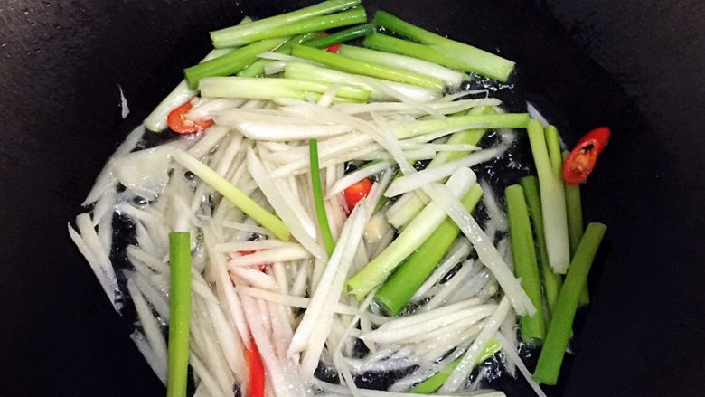 姜葱爆虾,锅里放油加热,依次放入姜丝,葱白和辣椒