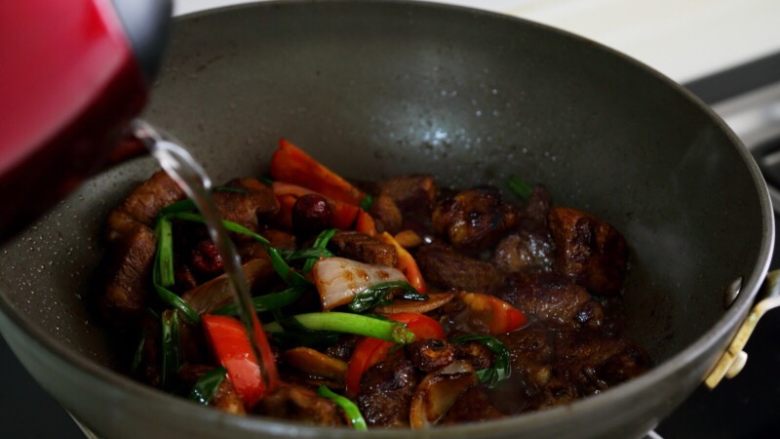 土豆烧牛肉,8.炒出香味加入热水,与肉平齐。