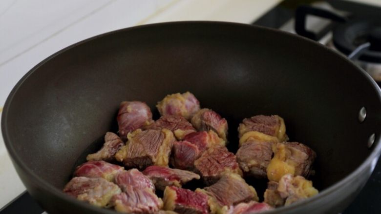 土豆烧牛肉,4.取一炒锅,不用油,用中小火将牛肉炒出水分,炒出的水用厨房纸沾去。