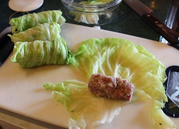 高丽菜牛肉卷,将高丽菜叶放入滚水中烫软后捞出备用。将肉团捏成适当大小的长条,用烫好的高丽菜叶卷成高丽菜卷备用。