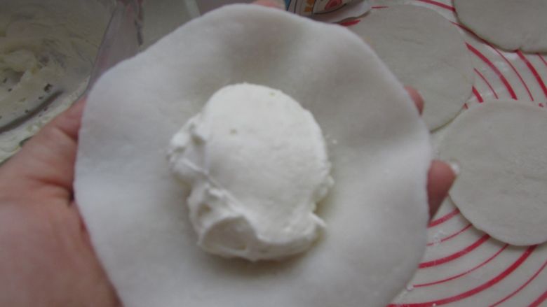 芒果雪媚娘,把奶油放到皮上,再放上芒果块。