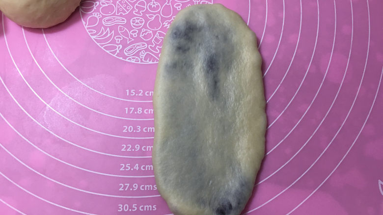 豆沙馅辫子面包(汤种法),收口处放在下方,用擀面杖擀成椭圆形。