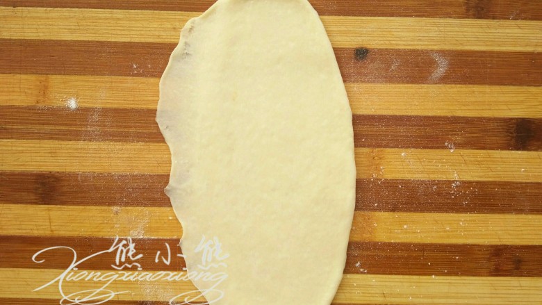 小兔子肠仔包,取一个面团,擀成椭圆形,再将一边擀薄。