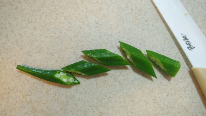 捞汁秋葵,秋葵改刀,切成菱形块。