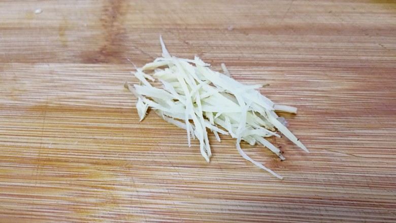 粤式清蒸鲈鱼,蒸鱼的时候来处理其它姜葱。用一个熟食专用的砧板和刀,把另一部分生姜切丝。