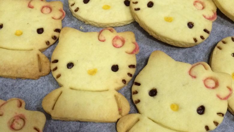 hellokitty饼干,继续用红色和黄色的巧克力分别给hellokitty画上蝴蝶结和嘴巴的轮廓。