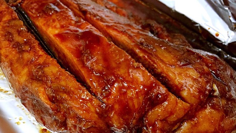蜜汁烤肉,换锡纸,然后将烤肉翻一面,为了容易烤熟,在肉片上划两刀,刷一层蜂蜜和老抽,入烤箱继续烤15分钟。