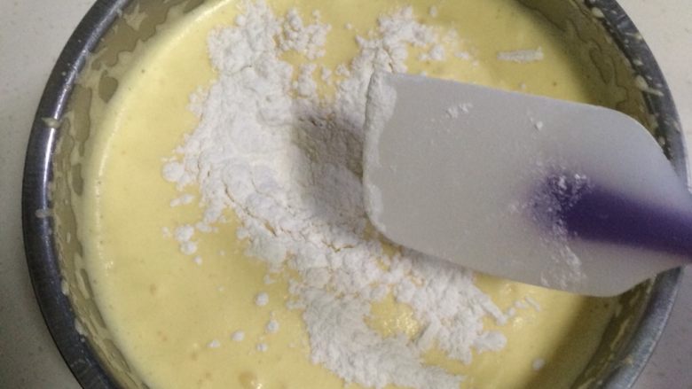 奶油水果蛋糕杯,在打发好的蛋糊中分两次加入低粉翻拌均匀(提前把低粉过筛备着),剩下一点低粉加入橙汁和玉米油混合的液体中拌匀。