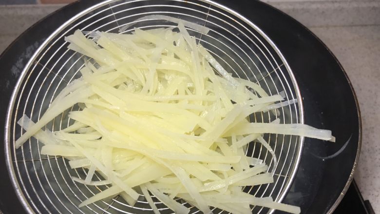 凉拌酸辣土豆丝,把土豆丝煮熟捞起，别煮太烂。