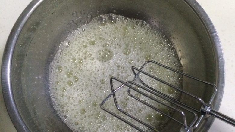 红丝绒奶油蛋糕杯,用电动打蛋器低速把蛋白打至粗泡,加入1/3细砂糖后继续搅打。
