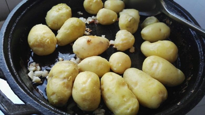 麻辣孜然小土豆,放入小土豆煎制(煎之前用刀把小土豆压扁,我忘提前压扁了,倒锅里后用松肉锤压的,一压扁占地方,有点太满了)。