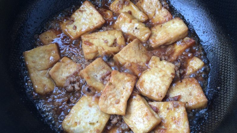 香煎豆腐,放入煎好的豆腐块,轻轻颠炒均匀,焖至汤汁快收干时,出锅装盘
