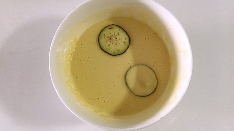 茄饼健康做法,茄片放入碗中，两面都沾上糊。