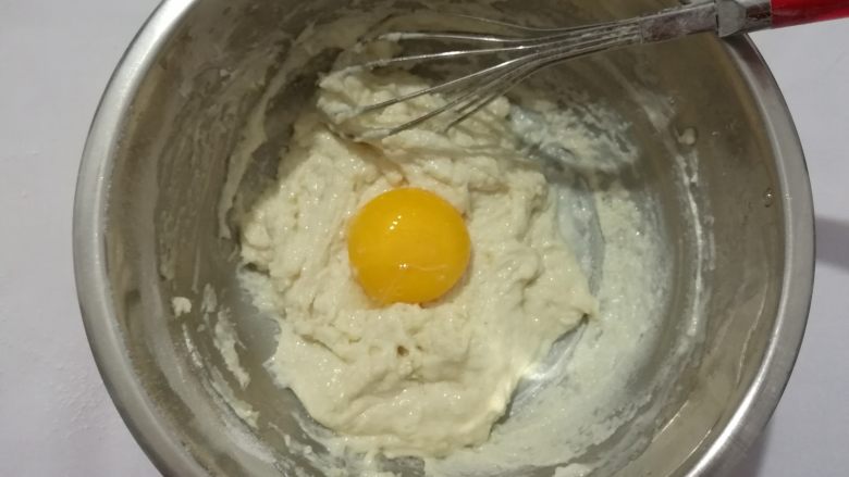 养生枸杞戚风蛋糕,一字型或十字形混合均匀,(不可划圈搅拌,以免起筋),搅拌均匀后加入一个蛋黄。