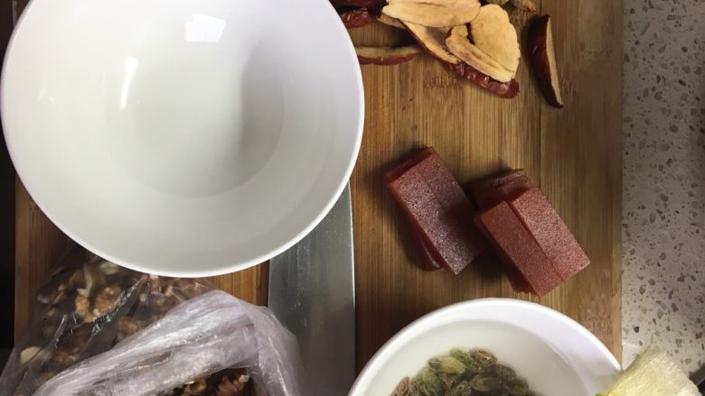 甜饭,这是所有的果干和做甜饭所用的碗,一个都不能少哦,一个大点的枣切成4-5瓣,并去核,山楂糕尽量切薄一点,核桃不用去皮,也是为了中和甜味。