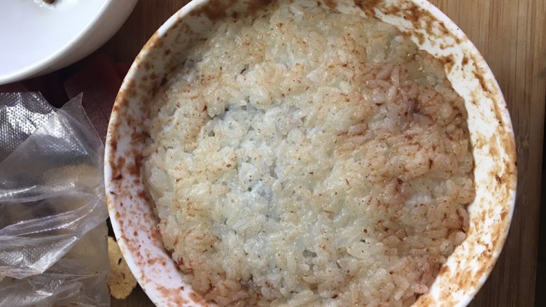 甜饭,豆沙馅铺好后,再放上一层糯米,大约1-1.5cm的样子,同样要压紧,不然可能会导致倒扣的时候分层