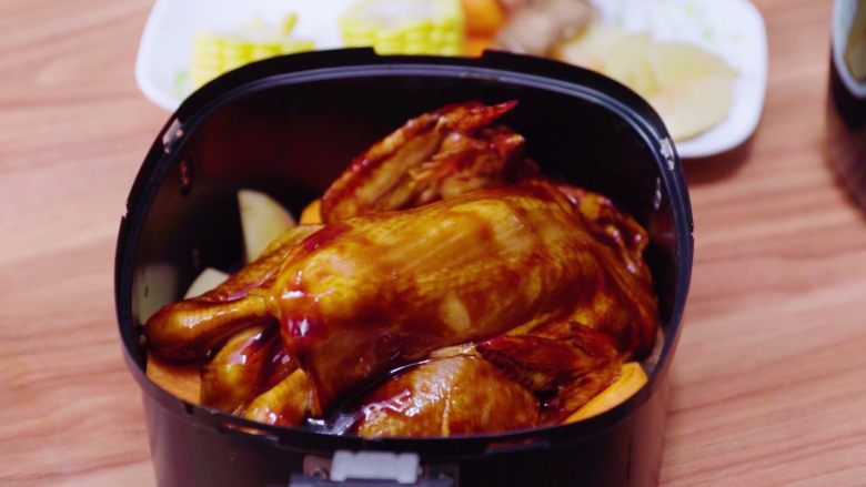 私房炸鸡,用切好的配菜放入空气炸锅中打底，再放入整只鸡