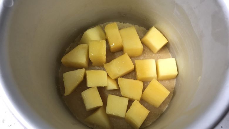 夏日芒果慕斯,取出冷冻好的饼干底,放入适量芒果块。