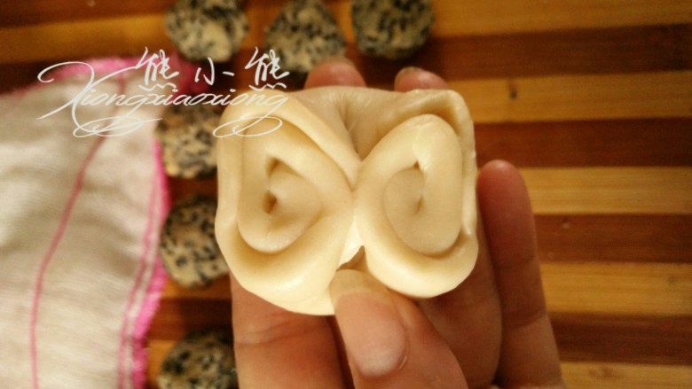 椒盐酥,取一个擀卷好的面团,用手在中间按一下,使面卷卷对折。
