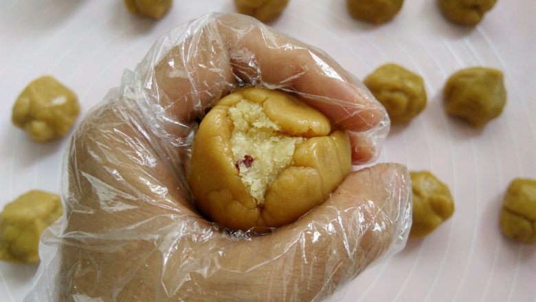 椰蓉蔓越莓月饼,手心合起来,用虎口把面团慢慢收圆,皮厚的地方可以推到皮薄的地方,尽量推的均匀一点