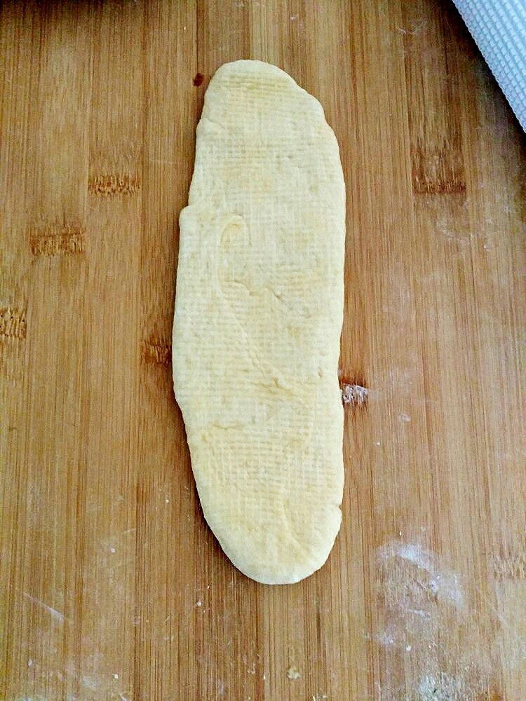 小红豆包,把长条擀成长舌状,把红豆沙涂抹后,从上往下卷起来,卷的时侯两边要收紧一点。