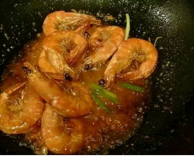 鲜味虾,约1、2分钟后,开盖,投入葱段,加盐调味,大火收汁,约20秒,见汤汁收紧、油亮、颜色变深是,即可出锅。