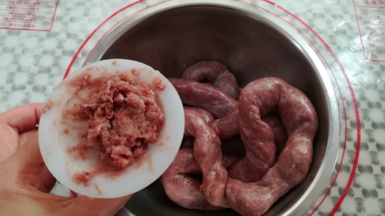 自制脆皮肠,把肉沫从漏斗口用筷子缓慢的灌到肠衣里,别把肠衣弄破了
