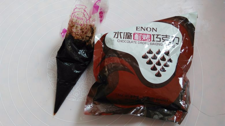 棉花糖淋酱饼干,等待饼干放凉的时候准备<a style='color:red;display:inline-block;' href='/shicai/ 9380'>巧克力酱</a>,10克巧克力装入裱花袋隔水融化,用之前一直泡热水里,用的时候在裱花袋上剪个小口子