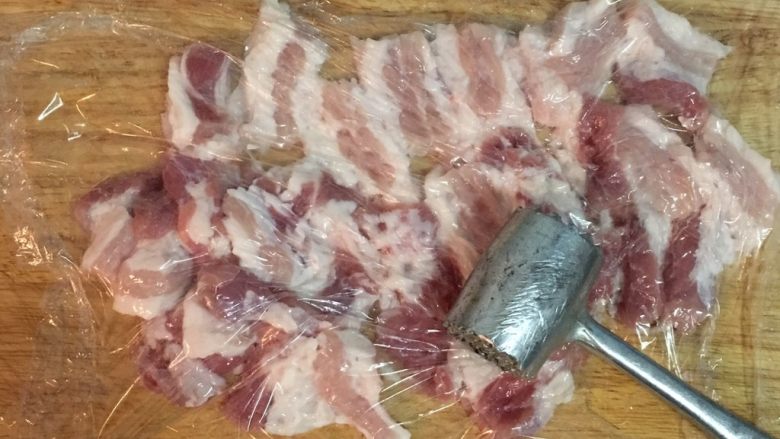 蜜汁黑胡椒豬肉乾,然後用保鮮膜蓋著,利用手邊有的工具將肉片拍鬆,