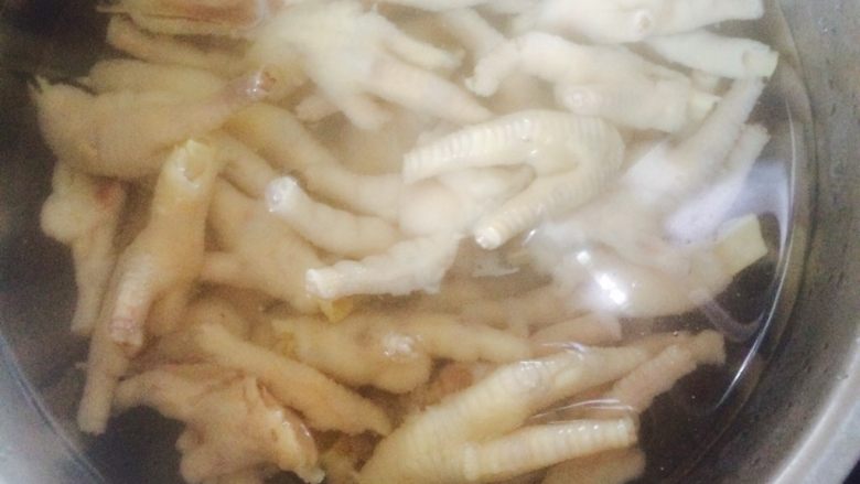 泡椒凤爪,将鸡爪反复在水中冲洗，去除油脂后将鸡爪对半切开，放入冰水中。