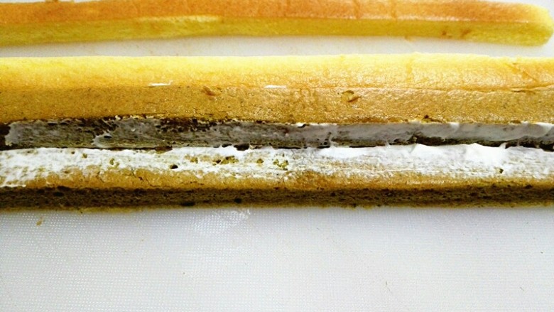 格子蛋糕,将两种蛋糕条交替摆放,接触面涂适量淡奶油,起固定作用,