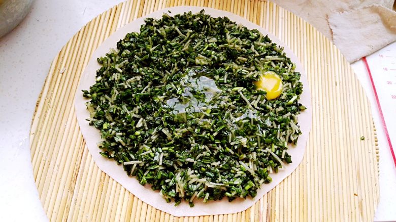 鸡蛋韭菜粉条馅菜馍(驻马店特色),取一个鸡蛋磕个小口,均匀甩在菜上。(也可把鸡蛋磕碗里用筷子搅匀再均匀倒菜上。这样的蛋液少油清淡更营养。)(还可把蛋液炒熟冷凉切碎拌馅中,那样