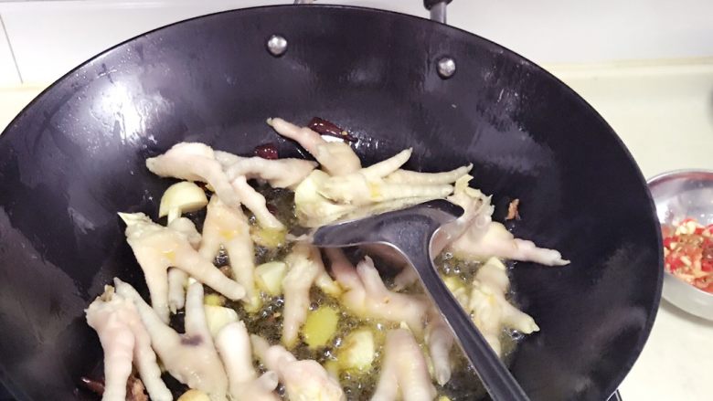 红烧凤爪,油热以后把姜蒜香料放入炒香倒入<a style='color:red;display:inline-block;' href='/shicai/ 89'>鸡爪</a>炒至变色再倒入醪糟水炒香