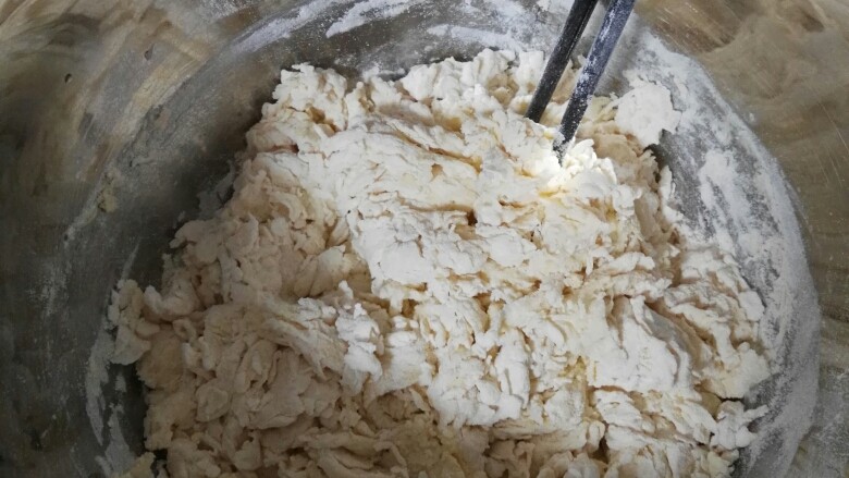 玉米开花馒头,十分钟后加入面粉,用筷子一个方向搅拌面粉,使面粉和水均匀融合,最后成絮状即可。