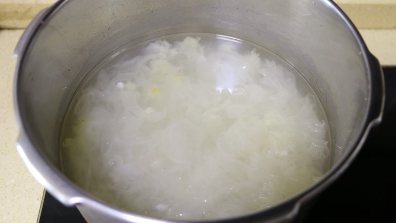 莲子百合银耳羹,高压锅下汽后,打开锅盖,这时的银耳已经煮得有些粘稠状了