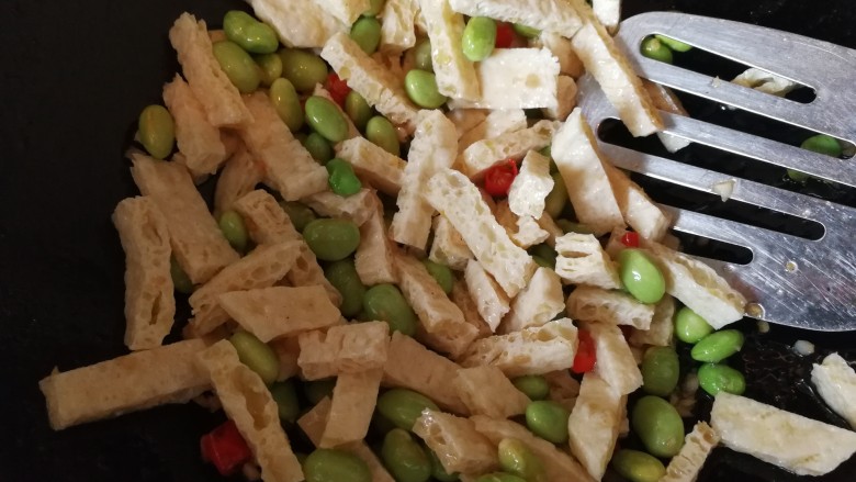 绿色美食+鸡毛菜脆皮豆腐炒毛豆,倒入脆皮豆腐,炒一会儿,不要太长时间。