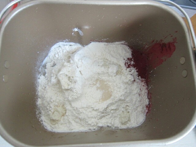 红丝绒麻薯软欧,除<a style='color:red;display:inline-block;' href='/shicai/ 887'>黄油</a>外,将面团材料与切成块的老面70克混合均匀。