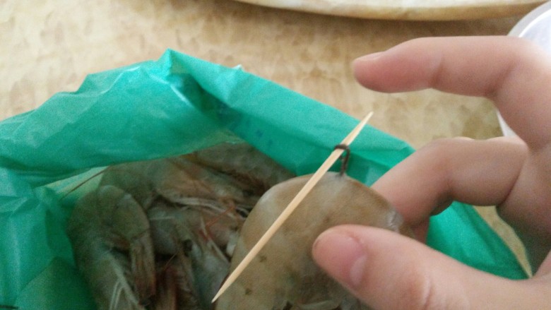 客人来了怎么办!中午吃什么!,虾线大家应该都会处理吧?用牙签从中间穿过去,挑出,拉出来。虾线就非常完整地取出来了。