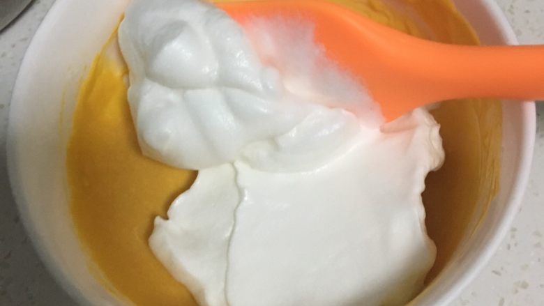 南瓜溶豆,取一半蛋白糊放入南瓜泥中,用翻拌手法搅拌均匀